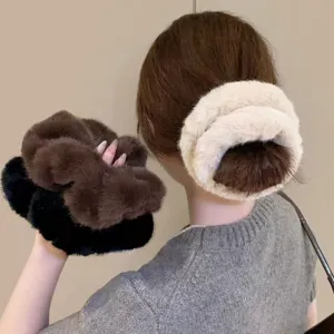 Close-up of fluffy faux fur hair scrunchie, soft plush bun holder, elegant winter hair accessory detail.