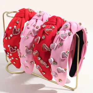 Fashionable wide knotted hairbands featuring pearls, rhinestones and love heart charms, detail view.