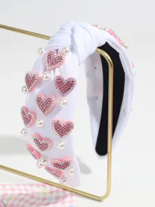 White knotted headband featuring pink rhinestone hearts and faux pearls for women fashion.