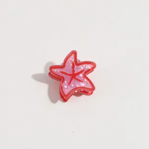 Détail de mini pince à cheveux étoile de mer, accessorio rose pour frange et style.
