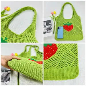 Detailansicht der grünen Häkeltasche mit rotem Erdbeermuster und offenem Netz-Design.