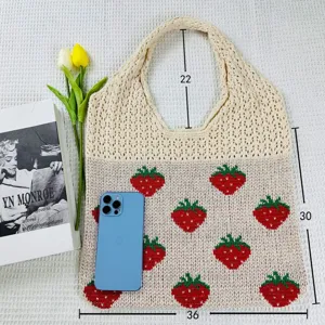 Gedetailleerd overzicht van gebreide shopper tas aardbeien patroon schoudertas textuur.
