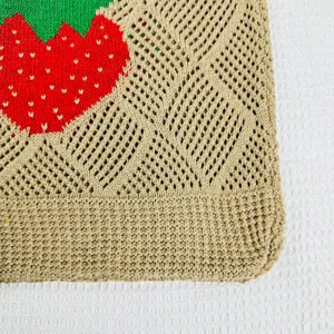 Detailansicht einer niedlichen gestrickten Erdbeere-Tasche mit stilvollem Lochmuster-Design.