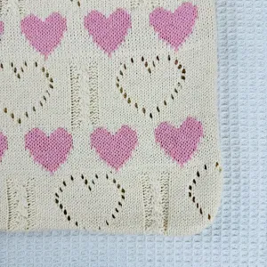 Stricktasche Detailansicht zeigt rosa Herz Jacquard Muster und hohles Strick Textur Design.