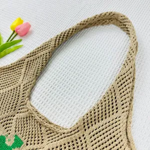 Nahaufnahme des gehäkelten Schultertaschengriffs, hochwertige beige Strickstruktur Optik.