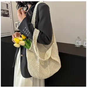 Detailaufnahme der beigen gestrickten Loch-Schultertasche,lässiges Strand-Netztaschen-Design.