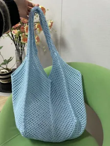 Hellblaue Häkel-Tasche, gestrickte Strandtasche mit Lochmuster und feiner Textur.