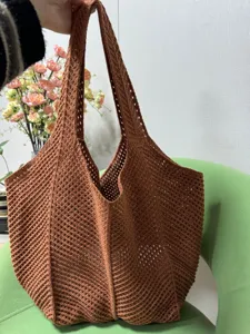Braune gestrickte Loch-Tasche im Detail, die die einzigartige gewebte Netztextur zeigt.