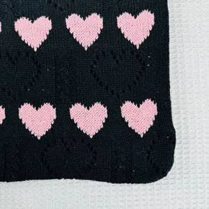 Detailansicht der Stricktasche mit schwarzem Stoff und rosa Herzmuster Webtextur nah