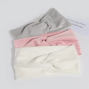 Close-up detail of soft velvet twist headbands in grey, pink and white colors for daily wear.