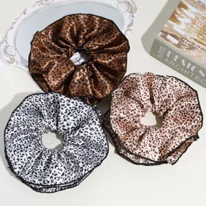 Detailed view of large leopard print satin hair scrunchies, elegant hair accessories set.
