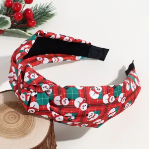 Detailed close-up of Christmas knotted fabric headband with cute snowman and classic plaid print.