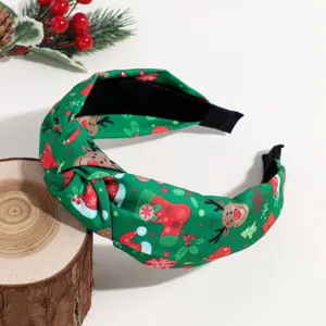 Detail view of a green Christmas knotted headband with cute elk and snowflake print fabric.