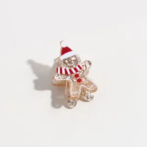 Detalle en primer plano de una pinza de pelo de jengibre navideño con purpurina dorada.
