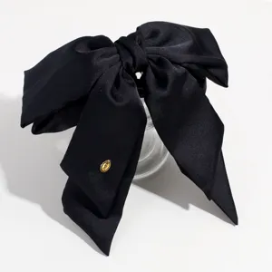 Detailed view of a black satin bow hair claw clip featuring soft fabric and a sturdy grip.