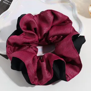 Oversized two-tone metallic purple and black fabric hair scrunchie detailed close-up shot.