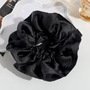 Oversized black glossy hair scrunchie elegant shiny fabric ponytail holder accessory.