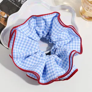 Large blue and white gingham hair scrunchie with bold red edge for women styling.