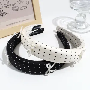 Cerchietti a pois bianchi e neri con dettagli di fiocchi di perle, accessorio elegante.