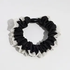 Elegant black satin scrunchie featuring delicate white lace trim and a stylish center black bead.