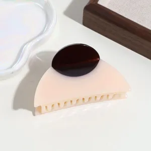 Primo piano dettagliato di una clip per capelli bicolore semicircolare, accessorio chic.