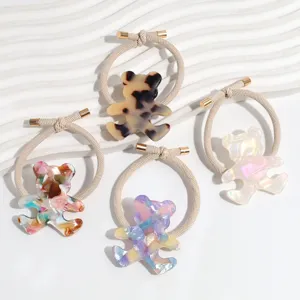 Close-up detail of cute bear acrylic hair ties, featuring assorted marble patterns and elastic rope.