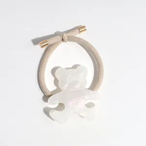 Minimalist pearl bear hair tie with metallic ends, elegant ponytail holder accessory.
