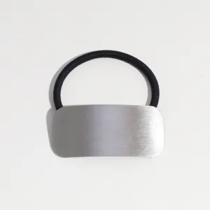 Vue détaillée de l'élastique à cheveux minimaliste en métal avec finition brillante élégante.