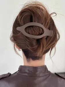 Primo piano di una molletta per capelli ovale marrone opaco elegante per acconciature.