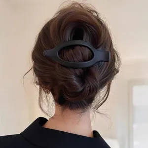 Dettaglio molletta per capelli ovale nera opaca, elegante fermaglio minimalista donna.