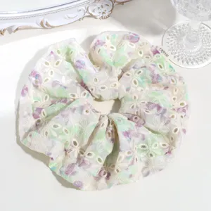 Close-up detail of a sweet floral embroidered hair scrunchie with delicate eyelet lace design.
