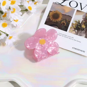Vista detallada de una linda pinza para el cabello de flor rosa con centro amarillo diario.