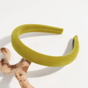 Gedetailleerd overzicht van een brede fluwelen haarband in geelgroen, zachte textuur mode.