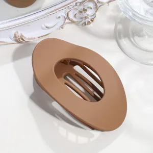 Nahaufnahme einer matten braunen ovalen Haarkralle mit hohlem Schlitzdesign für sicheres Styling.