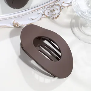 Braune matte flache ovale Haarklammer Nahaufnahme, minimalistischer Haar-Accessoire-Stil.