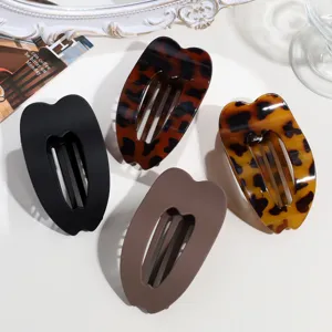 Vista dettagliata di mollette per capelli ovali alla moda in tinta unita e leopardate chic.