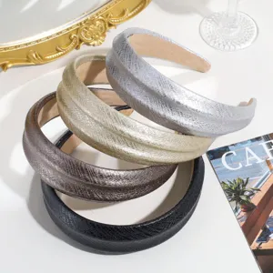 Primer plano detallado de diademas anchas de cuero con estampado de serpiente chic.