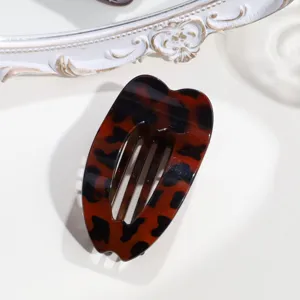 Dettaglio molletta per capelli a cuore tartarugato, design piatto per styling comodo e raccolti.