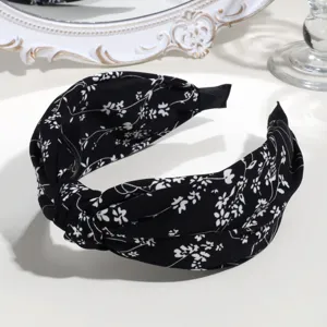Chic black and white floral knotted headband for women, wide brim fashion hair accessory.