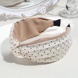 Chic polka dot knotted headband detail showcasing elegant beige and black daily style.