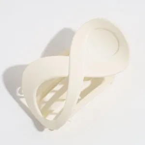 Detalle de pinza para cabello minimalista en forma de 8, elegante accesorio crema mate diario.