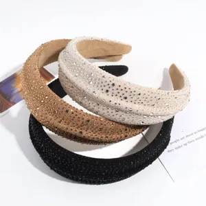 Vista detallada de diademas anchas y brillantes decoradas con pedrería elegante.