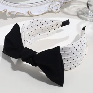 Black and white polka dot headband with elegant bow knot detail, perfect for daily fashion wear.