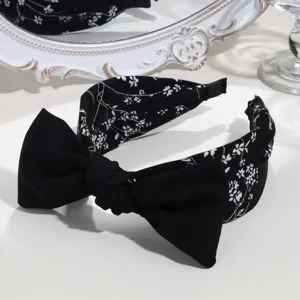 Black and white floral headband with cute bow detail, wide knotted hair hoop accessory.
