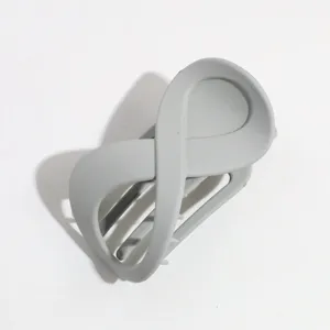 Vista detallada de la elegante pinza para el cabello gris mate en forma de 8, diseño minimalista.