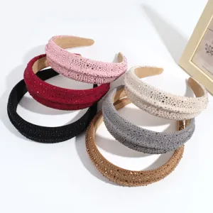 Primer plano de diademas acolchadas brillantes con pedrería en varios colores ricos y vivos.