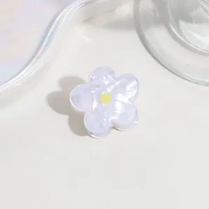 Detailed view of the cute translucent mini flower hair claw clip with yellow center design.