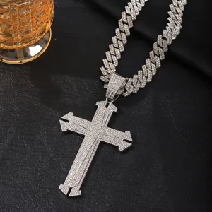 Detailed view of iced out cross pendant with cuban link chain, luxury hip hop jewelry.