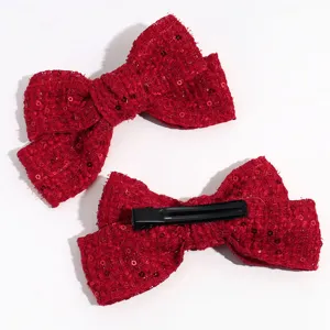 Primer plano detallado de una pinza para el cabello con lazo de tweed rojo y cierre.