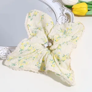 Close-up detail of the sweet yellow floral scrunchie featuring delicate lace trim and soft fabric.